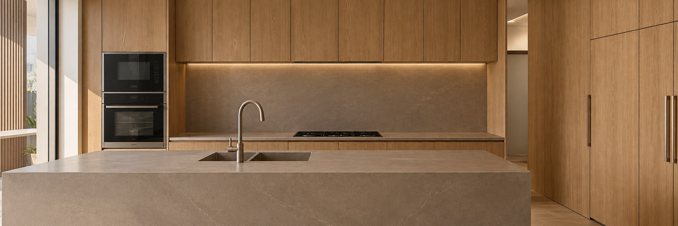 Warm oak indoor kitchen cabinetry with stone island